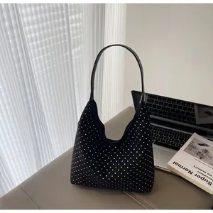 Detail of a black hobo bag with sparkling rhinestones set against minimalist home decor