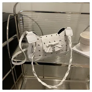 Détail du sac plissé blanc en cuir PU avec motifs nœuds noirs et pendentif en cœur