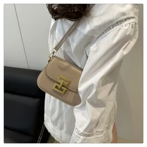 Detail einer beigen minimalistischen Umhängetasche mit markanter goldener quadratischer Schnalle