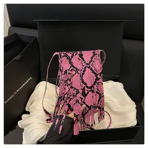 Pink and black snakeskin crossbody bag with tassel details in a premium gift box