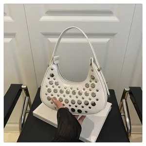 Detailed shot of white hobo bag with silver metallic studs and sleek top handle strap