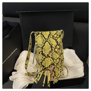 Detailed shot of yellow python texture handbag with fringe tassels in a gift box