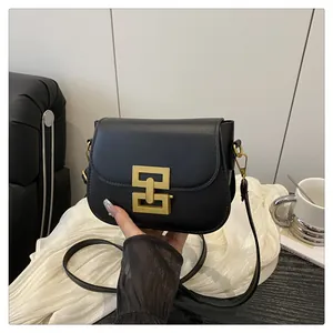 Detailansicht der schwarzen Schultertasche mit goldener Metallschnalle aus glattem Leder