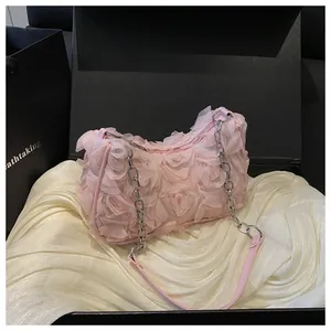 Détail du sac de soirée rose avec pétales 3D dans un coffret cadeau de luxe
