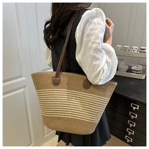 Detail of striped woven tote bag with premium brown leather straps for daily commute