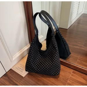 Mirror reflection showing details of a black rhinestone hobo bag with leather straps