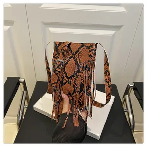 Detailed close-up of retro snake skin print crossbody bag with long tassel decoration