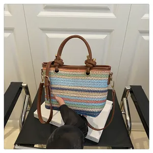Macro shot of colorful striped woven texture with premium brown leather handles and gold metal