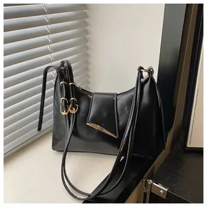 Detail of black leather saddle bag with golden metal buckles and triangular edge accents