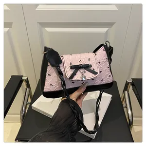 Détail du tissu plissé rose avec imprimé chat, nœud noir et pendentif cœur argenté