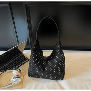 Detail of black suede hobo bag with silver rhinestone dots and wide shoulder strap