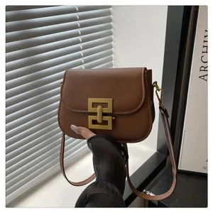 Nahaufnahme der braunen Leder-Satteltasche mit markanter goldener geometrischer Schnalle