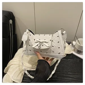 Détail du sac à épaule blanc en PU avec nœud, pendentif cœur et sangle tressée