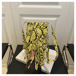 Detailed macro shot of yellow faux leather snakeskin texture and long fringe on mini bag