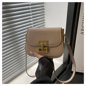 Details der beigen minimalistischen Umhängetasche mit goldener H-Schnalle im Retro-Stil
