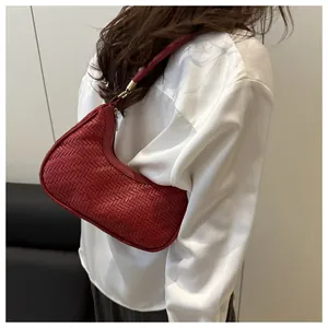 Dettaglio della trama intrecciata rossa della borsa a spalla con cerniera dorata