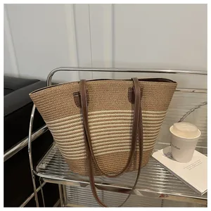 Detail of striped woven tote bag featuring brown leather straps on a minimalist cart