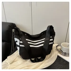 Détail d'un sac à bandoulière en nylon noir avec rayures et grand chiffre 3 imprimé