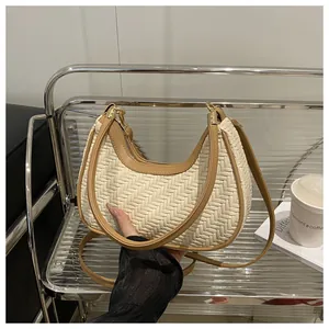 Dettaglio della borsa a mezzaluna intrecciata con finiture in pelle marrone
