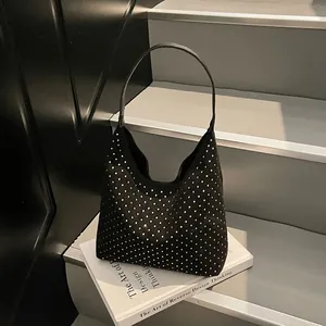 Chic black denim hobo bag with silver rhinestones on a stylish staircase background