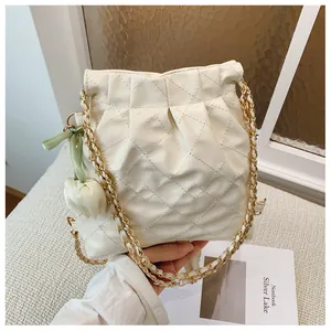 Detail of quilted leather bucket bag with chain strap and tulip charm decoration