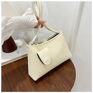 Close-up of cream woven faux leather shoulder bag with circular coin purse on wooden table