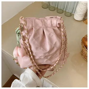 Detail of pink quilted PU leather bag with drawstring and golden chain strap and tulip charm
