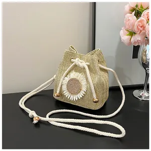 Detail of straw woven bucket bag with sunflower applique and drawstring closure