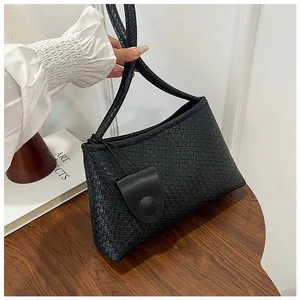 Close-up of black woven texture shoulder bag with small round coin pouch detail
