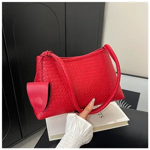 Detail of red woven leather shoulder bag with matching mini round pouch and top handle