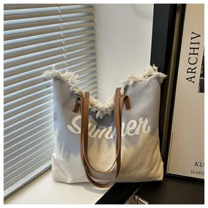 Detail of grey canvas tote bag with raw edges and Summer print on a white window sill