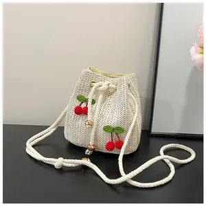 Close-up of woven bucket bag featuring 3D cherry embroidery and cotton rope drawstring