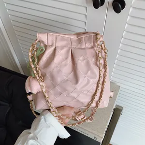 Pink quilted leather bucket bag with gold chain strap and floral charm detail