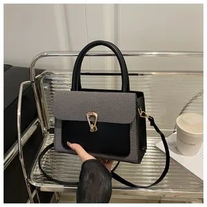 Detail view of woven grey and black leather crossbody bag with golden horseshoe lock
