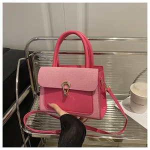 Detail of pink leather and twill patchwork handbag with golden U-shaped metal lock