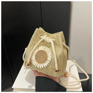 Detail of straw bucket bag featuring a 3D woven sunflower and cotton rope drawstring closure