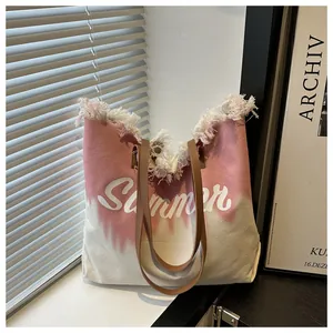 Detailed view of the frayed edges and Summer logo on the gradient pink canvas tote bag