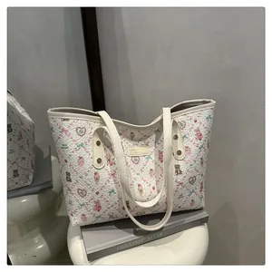 Detailaufnahme des plissierten Stoffes und des süßen Bärenprints dieser cremefarbenen Tasche