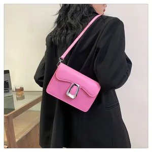 Pink PU leather square bag with silver U-shaped metal buckle on black blazer suit