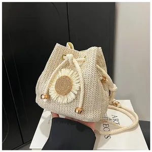 Detailed close-up of straw bucket bag with sunflower decor and drawstring closure