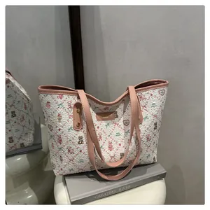 Detail der weißen Tragetasche mit rosa Bärenprint und Ledergriffen für Damen