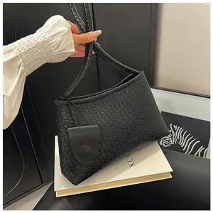 Detail of black woven leather handbag showing Intrecciato texture and decorative leather tag