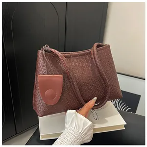 Detail of coffee brown woven texture shoulder bag with small hanging coin pouch accessory
