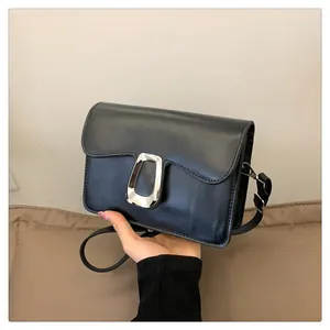 Detail of black leather square bag with silver horse-eye metal buckle and adjustable strap