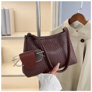 Detail shot of a dark brown woven leather shoulder bag with a vintage minimalist style