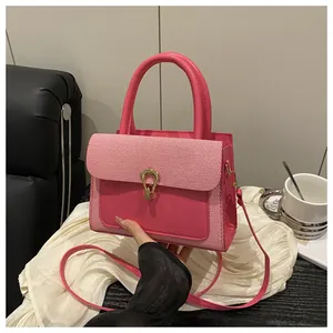 Detail of pink lychee pattern texture and gold horseshoe buckle on crossbody handbag