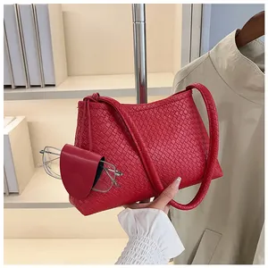 Detail of red woven shoulder bag featuring a matching mini pouch for eyewear
