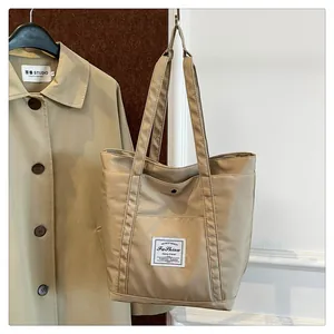 Primer plano del bolso tote de nailon beige con parche Fashion y botón a presión
