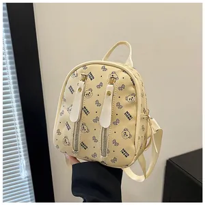 Detail of mini backpack featuring cartoon bear patterns and vertical metal zippers