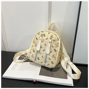 Detailed close-up of mini backpack featuring cartoon bear print and premium metal zippers
